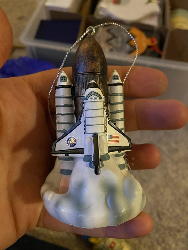 A space shuttle launch ornament in resin with a US flag and exhaust-plume base