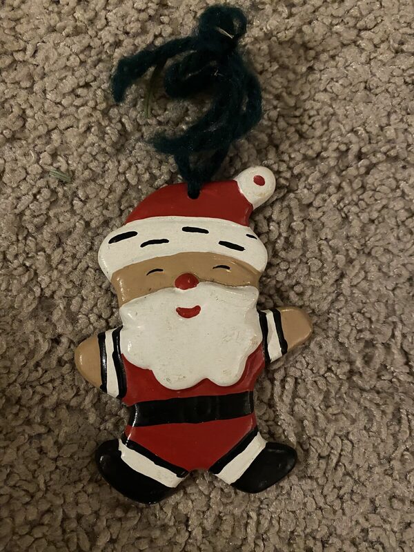 A flat painted Santa ornament with a yarn hanger