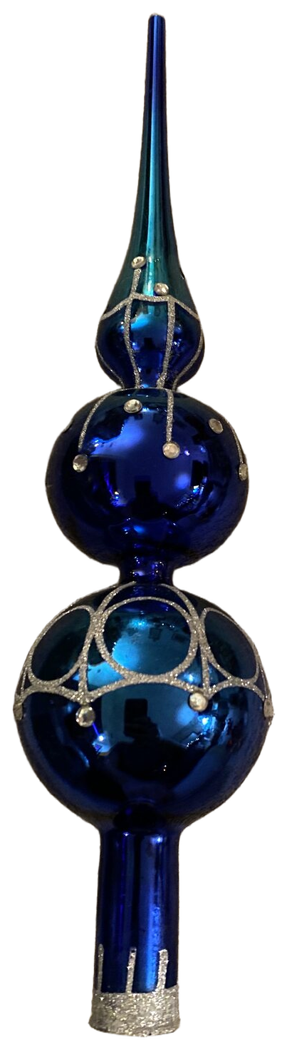 A cobalt blue glass tree topper, photographed tall against the dark